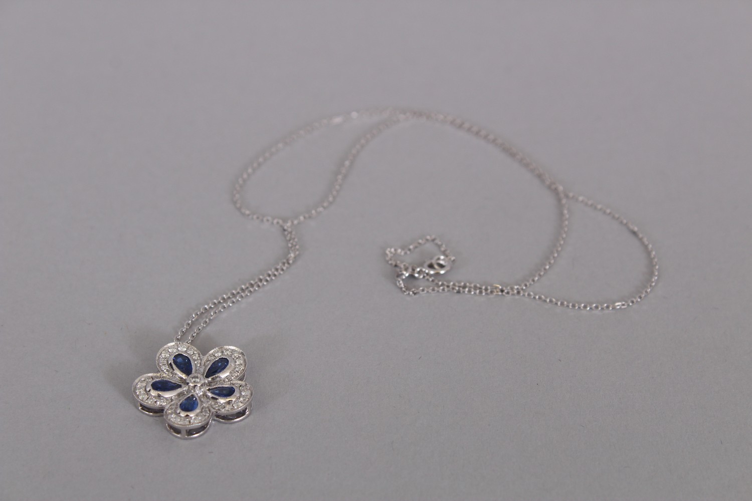 AN 18CT WHITE GOLD FLOWER SHAPED SAPPHIRE AND DIAMOND PENDANT NECKLACE OF 1.5cts. - Image 2 of 3