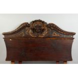 A 17TH-18TH CENTURY ITALIAN CARVED WOOD AND GILDED HEADBOARD carved with a mask. 45ins long x