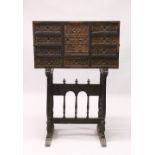 A 17TH / 18TH CENTURY SPANISH STAINED PINE VARGUENO ON STAND, with a central door, over a small