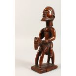 A TRIBAL CARVED WOOD FIGURE ON A HORSE. 9ins high.
