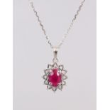 A 9CT GOLD, RUBY AND DIAMOND CLUSTER PENDANT AND CHAIN.