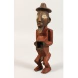 A CARVED WOOD TRIBAL FIGURE, fetish with red pigment. 8.5ins long.