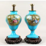 A PAIR OF SEVRES BLUE VASES painted with reverse panels of flowers and figures on Chinese wooden
