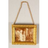 A TINY 9CT GOLD PICTURE FRAME with photographs. 3cms x 2.5cms.