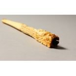 A CHINESE CARVED IVORY CIGARETTE HOLDER. 12cms long.