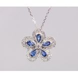 AN 18CT WHITE GOLD FLOWER SHAPED SAPPHIRE AND DIAMOND PENDANT NECKLACE OF 1.5cts.