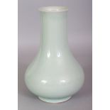 A CHINESE CELADON GLAZED PORCELAIN VASE, the sides applied with a pale even glaze, the base with a