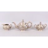 A GOOD CHINESE SILVER THREE PIECE TEA SET, decorated with dragon in relief, comprising teapot and