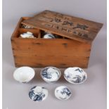 A QUANTITY OF ORIENTAL TEA BOWLS AND SAUCERS in a wooden box..