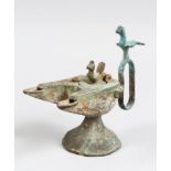 A SELJUK STYLE BRONZE OIL LAMP with two bird finials, 12cm high.