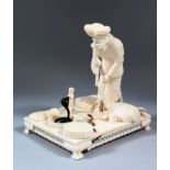 A GOOD 19TH CENTURY INDIAN CARVED IVORY GROUP OF A SNAKE CHARMER with three snakes, standing on a