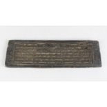A 19TH CENTURY TIBETAN WOODEN PRINTING BLOCK with calligraphy on each side, 33cm long, 10cm wide.
