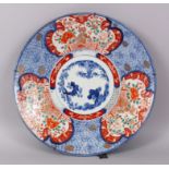 A GOOD JAPANESE IMARI PORCELAIN CHARGER, decorated with Shi-Shi dogs and floral scenes, blue and