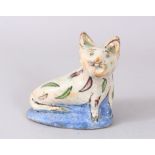 AN ISLAMIC QAJAR POTTERY CAT on a blue base, 13cm high.