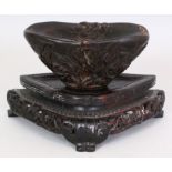 A 20TH CENTURY CHINESE CARVED HORN LIBATION CUP, together with a shaped hardwood stand, the libation