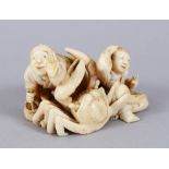 A GOOD JAPANESE IVORY OKIIMONO OF FISHERMAN AND BOY, the father protecting his catch whilst a