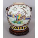 A CHINESE FAMILLE ROSE PORCELAIN JAR, together with a wood stand, decorated with panels of sages,