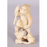 A JAPANESE MEIJI PERIOD IVORY OKIMONO OF A MONKEY, being attacked by a group of toads, 3.25in high.
