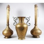 A TALL PAIR OF 19TH CENTURY PERSIAN QAJAR CHASED BRASS BOTTLE VASES, 70cm high and a two handled