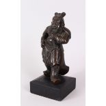 A 19TH CENTURY CHINESE BRONZE STANDING FIGURE OF GHANDI, on a wooden base. Figure 22cm high.