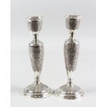 A PAIR OF PERSIAN WHITE METAL CANDLESTICKS, 19cm high.