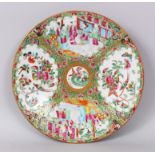 A CANTON CIRCULAR DISH painted in brilliant colour with four panels of figures, flowers, birds and