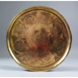 AN TURKISH COPPER GILT CIRCULAR DISH, engraved with flower heads, 28cm diameter.