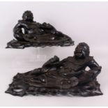 A GOOD PAIR OF CHINESE CARVED HARDWOOD RECLINING FIGURES, holding a dragon on a pierced base. 43cm