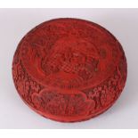 A LARGE CHINESE CINNABAR RED LACQUER CIRCULAR BOX AND COVER, the top and sides carved with figures