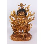A LARGE GILT BRONZE GOD, set with stones, standing on a figure. 45cm high.