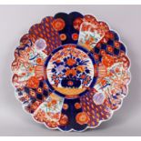 A JAPANESE IMARI CIRCULAR SHAPED EDGED CHARGER, decorated in red and blue with flowers. 39cm