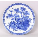 AN IMARI BLUE AND WHITE CIRCULAR DISH with wavy edge, the centre decorated with birds and flowers.