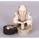 A SIGNED JAPANESE MEIJI PERIOD WOOD & IVORY OKIMONO OF A SEATED ARTISAN, holding a chisel above a
