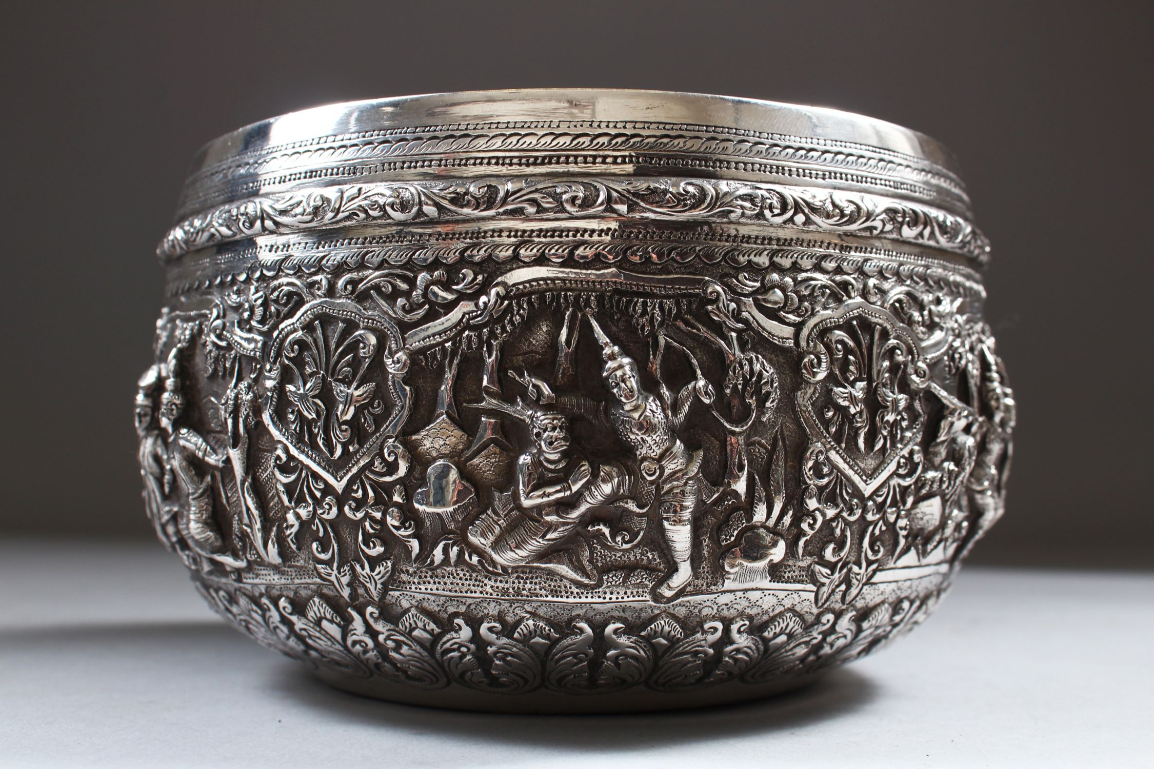 A 19TH CENTURY BURMESE SILVER CIRCULAR BOWL, 14.5cm diameter, the sides repousse with six panels