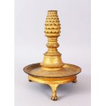 A THAI CIRCULAR GILDED CANDLESTICK on three claw feet, 27cm high.