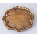 AN INDIAN BRASS SHAPED TRAY, engraved with dancing girls, 10cm diameter.