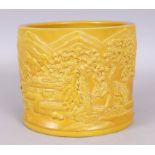 A LARGE CHINESE YELLOW GLAZED MOULDED PORCELAIN BRUSHPOT, the sides decorated with a continuous