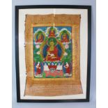 A FRAMED AND GLAZED THANGKA. 81cm x 54cm.