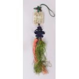 A GOOD CHINESE JADE PIERCED AND CARVED PENDANT,with attached silk drapes and tassels. 5cm wide x 7cm