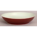 A CHINESE PORCELAIN DISH, of saucer shape, the exterior sides applied with a copper red glaze, the