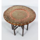A LARGE 19TH CENTURY ISLAMIC DAMASCUS HAND CHASED CIRCULAR COPPER TRAY, 60cm diameter on a folding