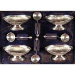 A SET OF FOUR PEDESTAL SALTS, with spoons, cased, Birmingham 1890.