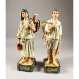 A PAIR OF CONTINENTAL MAJOLICA GLAZED POTTERY FIGURES, modelled as a fruit gatherer and water