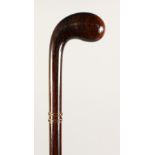 A "GOLF PUTTING" WALKING CANE, with two gold bands. 35.5ins long.