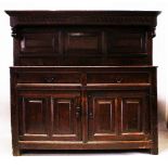 AN EARLY 18TH CENTURY OAK COURT CUPBOARD with carved and dated cornice 1703, over two panelled doors