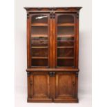 A VICTORIAN MAHOGANY CUPBOARD BOOKCASE, with moulded cornice, pair of glazed doors, over two