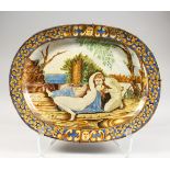 AN OVAL ITALIAN MAJOLICA DISH with an allegorical scene. 15ins long.