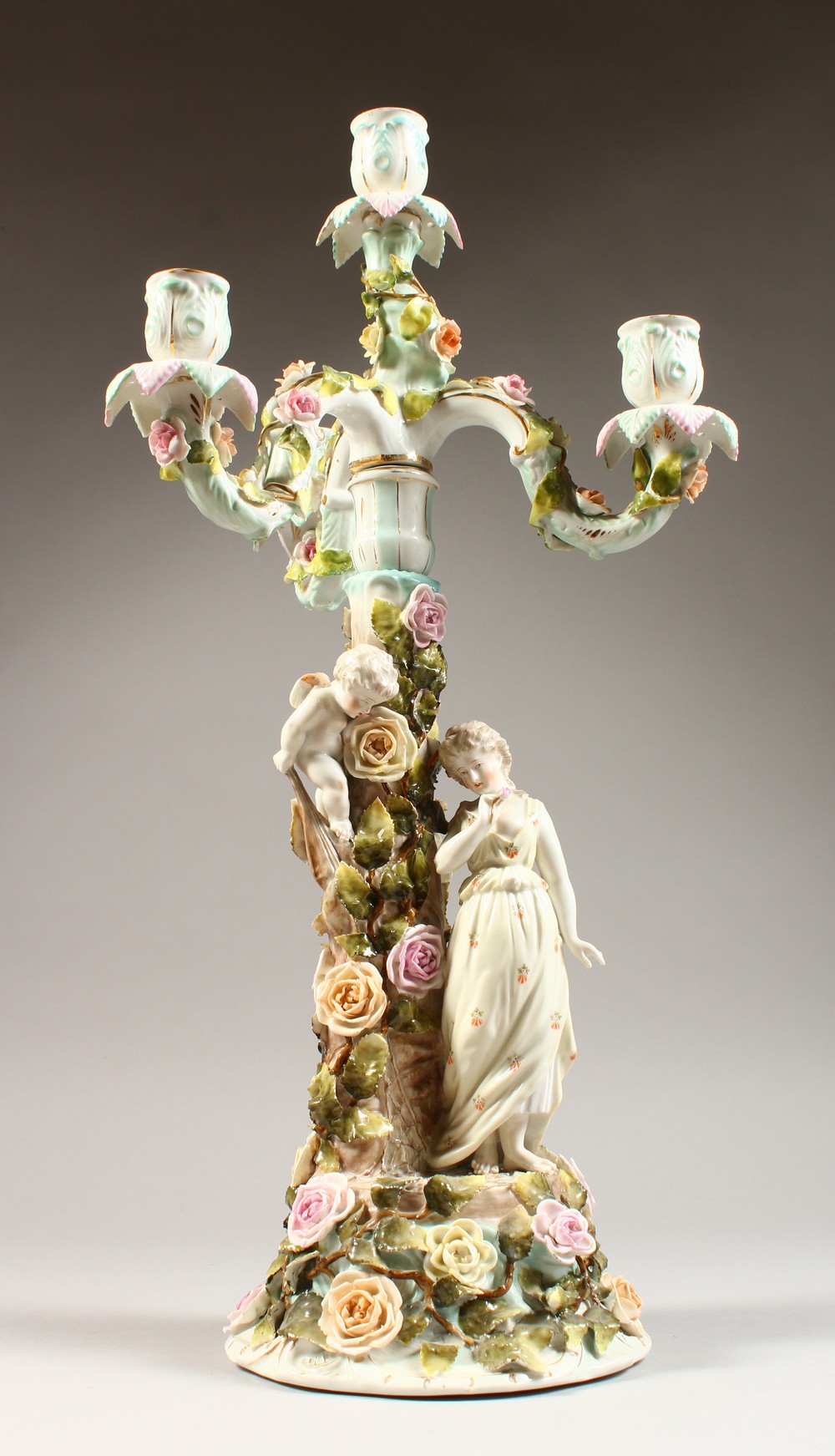 A SITZENDORF CANDELABRA, with three scrolling branches, the base with a young lady and cherub by a