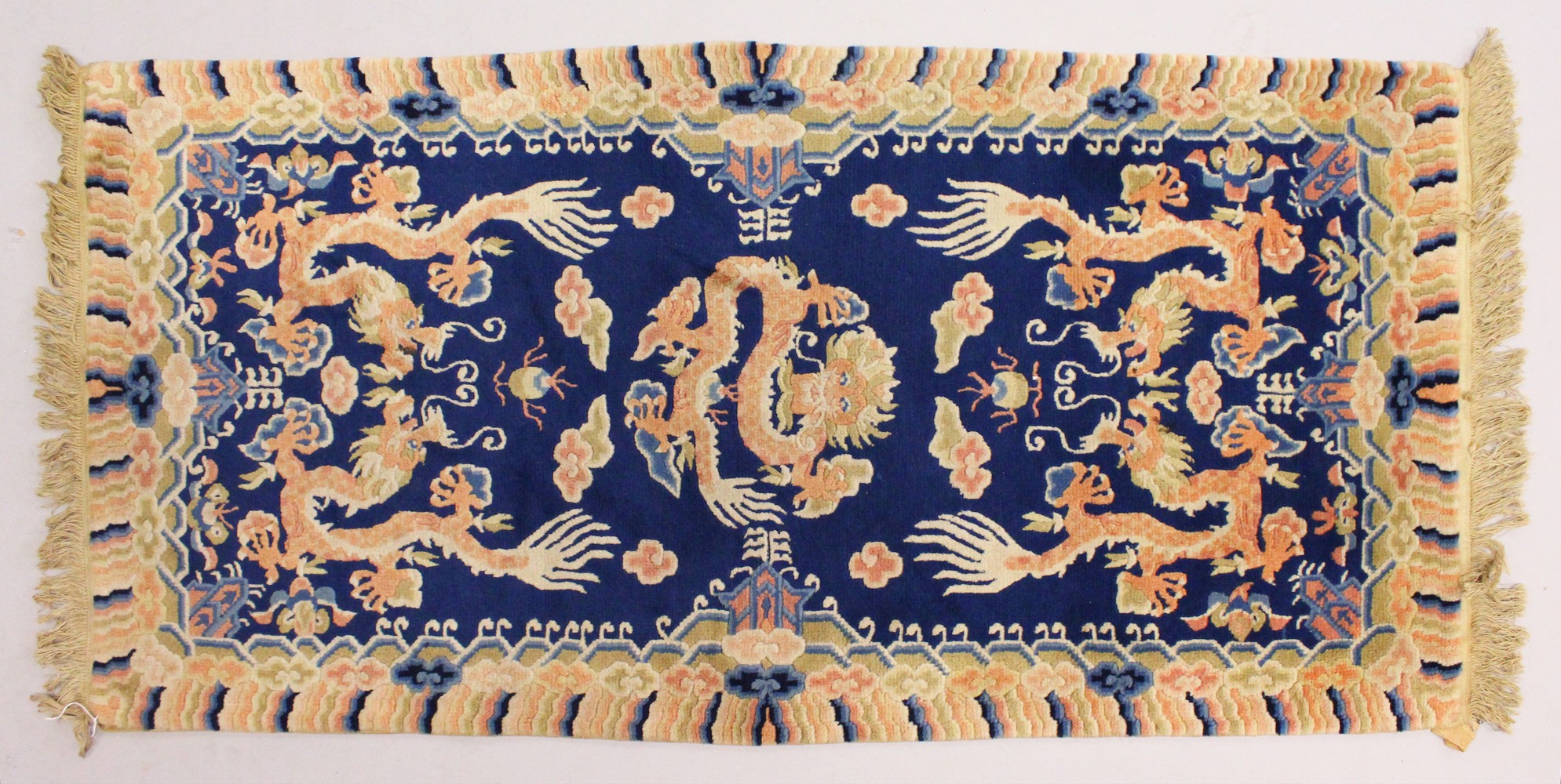 A CHINESE RUG, with blue ground and dragon motifs. 5ft x 2ft 4ins.