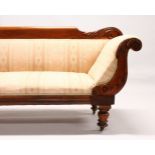 A VICTORIAN MAHOGANY SCROLL END SETTEE, with carved showwood frame, on turned legs. 6ft 8ins long.